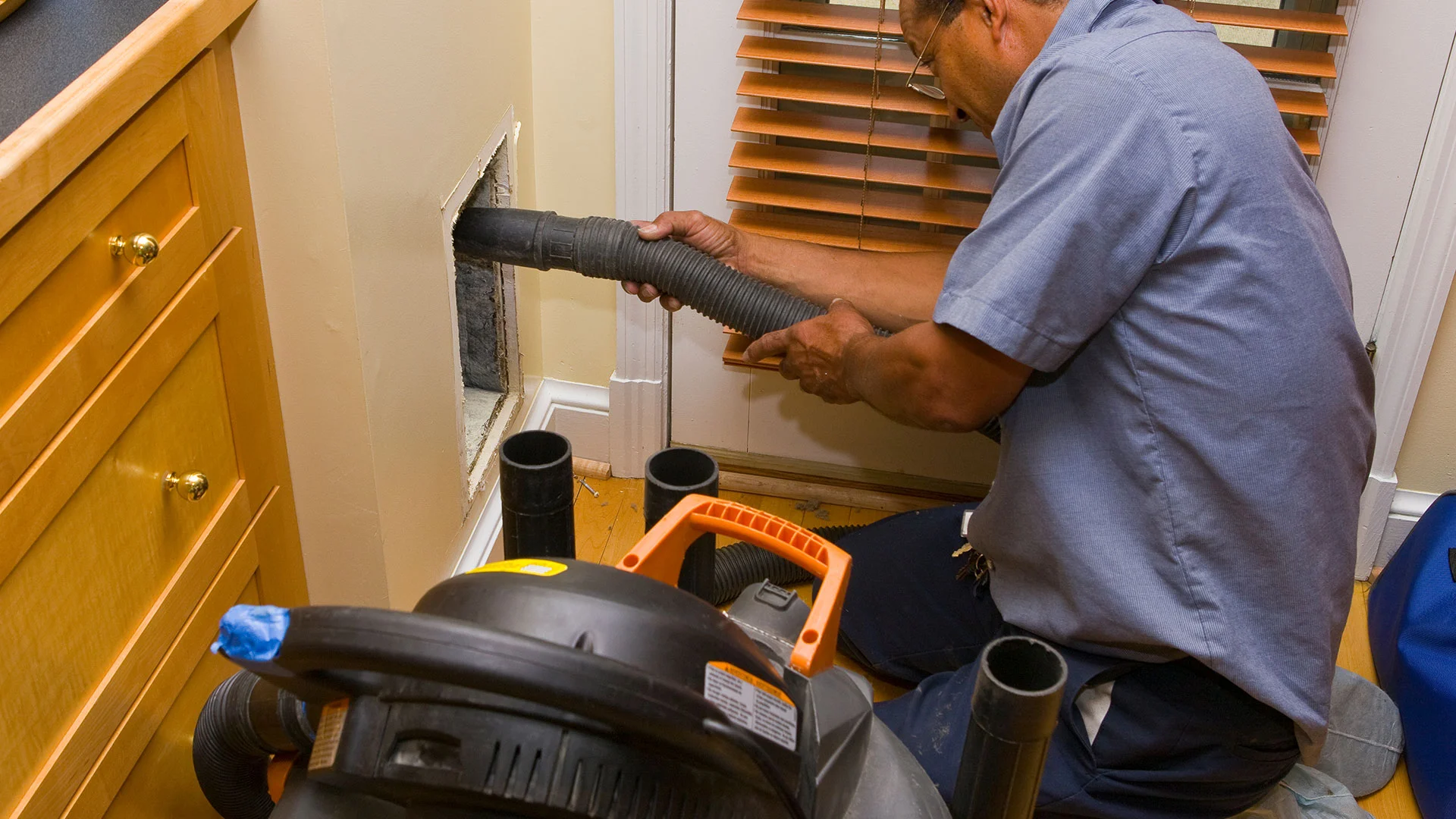 An Expert performing Air duct cleaning services using specialized equipments